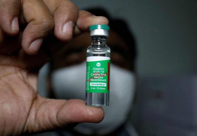 © Reuters. An official displays a vial containing COVISHIELD after a consignment of the vaccines arrived from the western city of Pune for its distribution, in Ahmedabad
