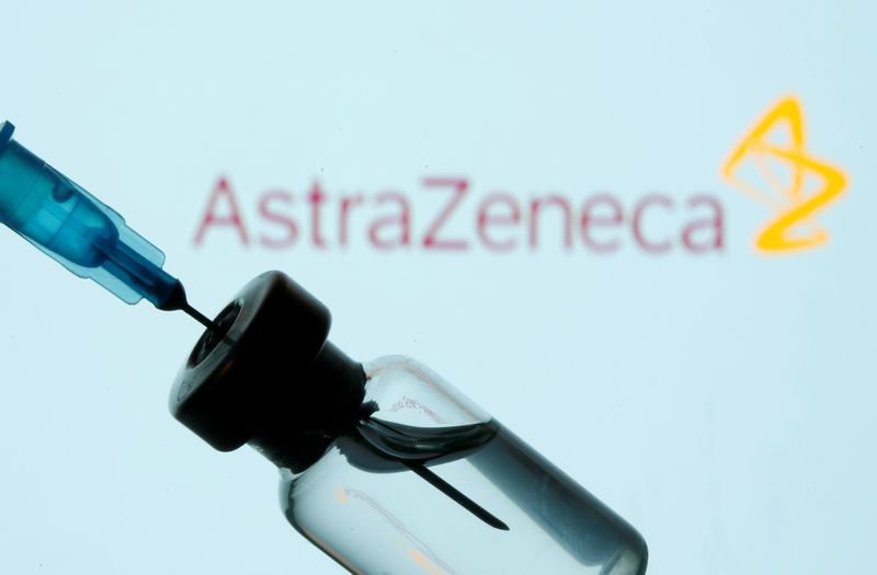© Reuters. Vial and sryinge are seen in front of displayed AstraZeneca logo