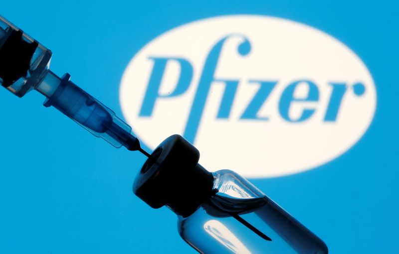 &copy; Reuters. Vial and sryinge are seen in front of displayed Pfizer logo