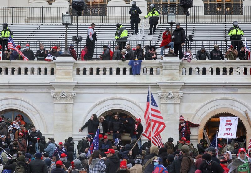 &copy; Reuters. Partidarios del presidente de Estados Unidos Donald Trump entran y salen por una ventana que rompieron y luchan con miembros de las fuerzas del orden en un acceso que abrieron por la fuerza durante su asalto al edificio del Capitolio de los Estados Unidos