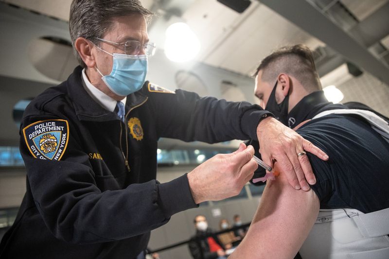 &copy; Reuters. Un miembro del Departamento de Policía de Nueva York recibe una dosis de la vacuna de Moderna contra al COVID-19 en la Academia de Policía de Queens, EEUU.