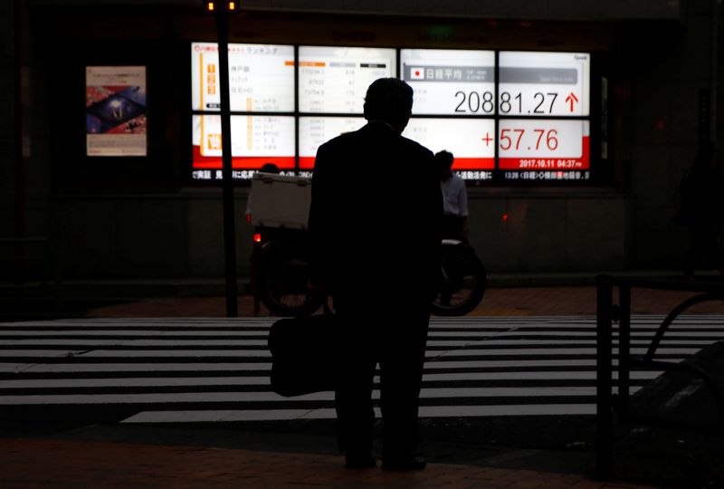 &copy; Reuters. A man stands in front of an electronic board showing Japan&apos;s Nikkei average outside a brokerage in Tokyo