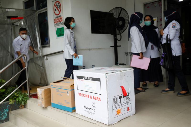 © Reuters. Officers carry off a box of the coronavirus disease (COVID-19) vaccine, in Jakarta