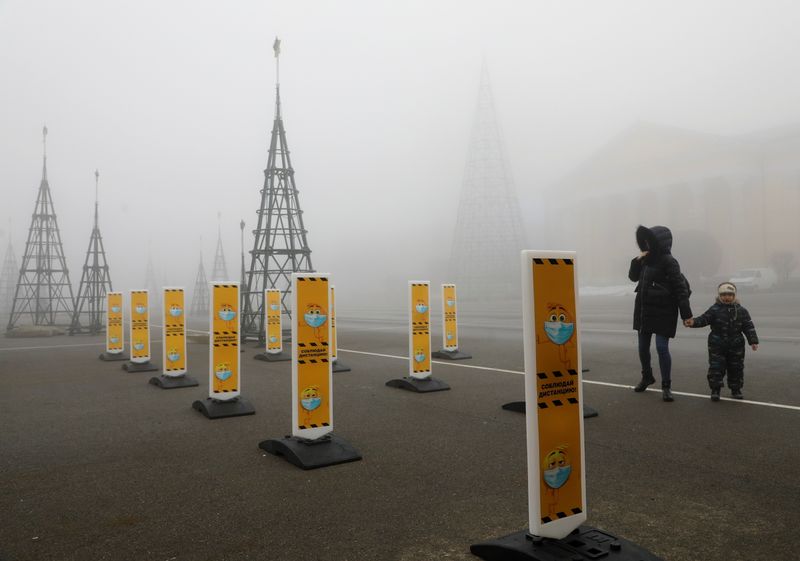 &copy; Reuters. Pedestrians walk past social distancing signs placed near a skating rink amid the coronavirus disease outbreak in Stavropol