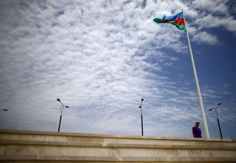 &copy; Reuters. Woman walks at the National Flag Square near a giant flag of Azerbaijan in Baku