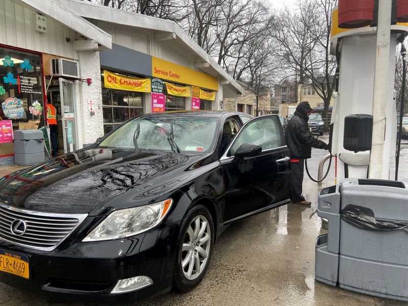© Reuters. FILE PHOTO: Julio Barrios attends to a customer at a gas station in Scarsdale