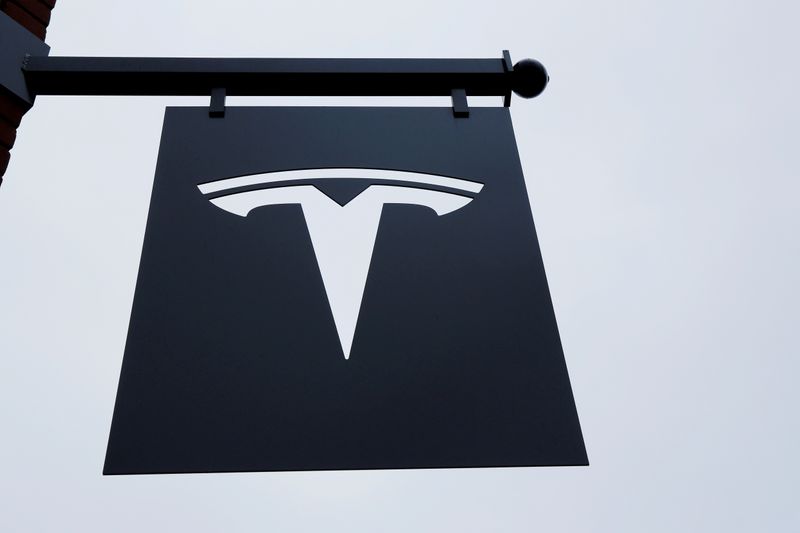 © Reuters. FILE PHOTO: A Tesla logo hang on a building outside of a Tesla dealership in New York