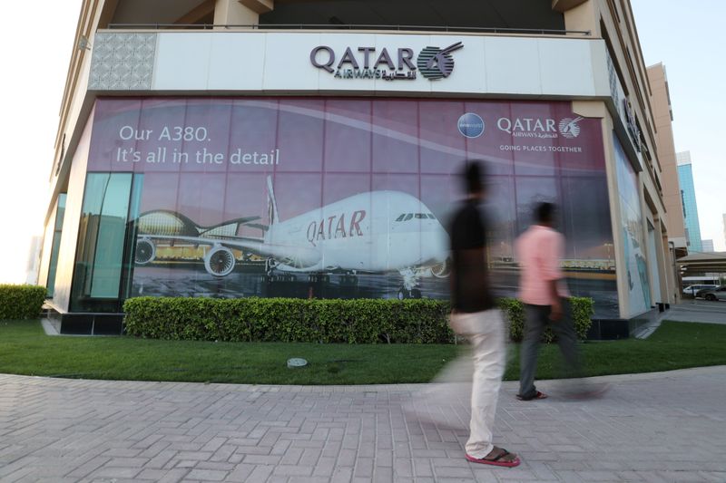 &copy; Reuters. FILE PHOTO: FILE PHOTO: People walk past Qatar Airways office in Manama