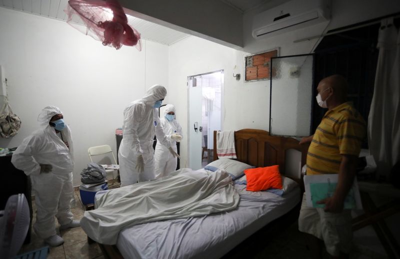 &copy; Reuters. Profissionais de saúde retiram corpo de paciente de Covid-19 que morreu em casa em Manaus