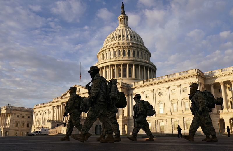 &copy; Reuters. National Guard members walk in front of the U.S. Capitol after the House voted to impeach U.S. President Donald Trump in Washington