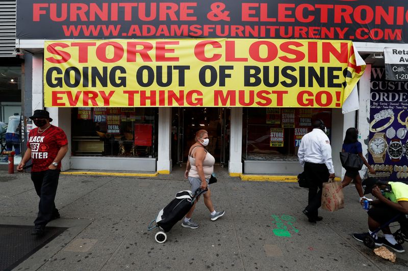 &copy; Reuters. People walk by a store going out of business along 125th street in the Harlem neighborhood of New York City
