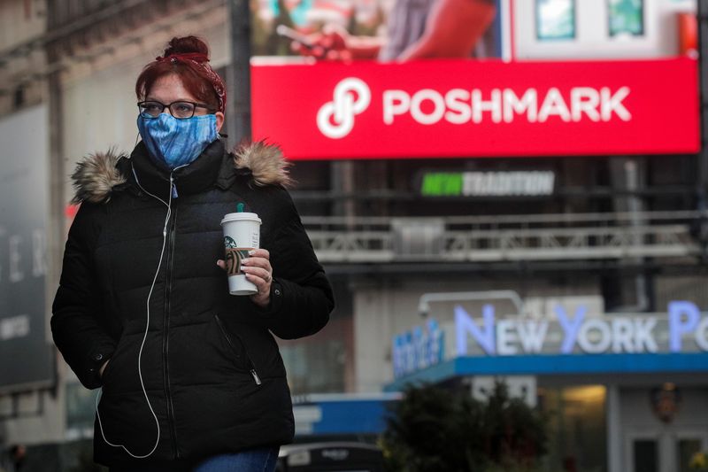 &copy; Reuters. A woman walks through Times Square as a screen displays the company logo for Poshmark Inc. during it&apos;s IPO at the Nasdaq Market Site in Times Square in New York
