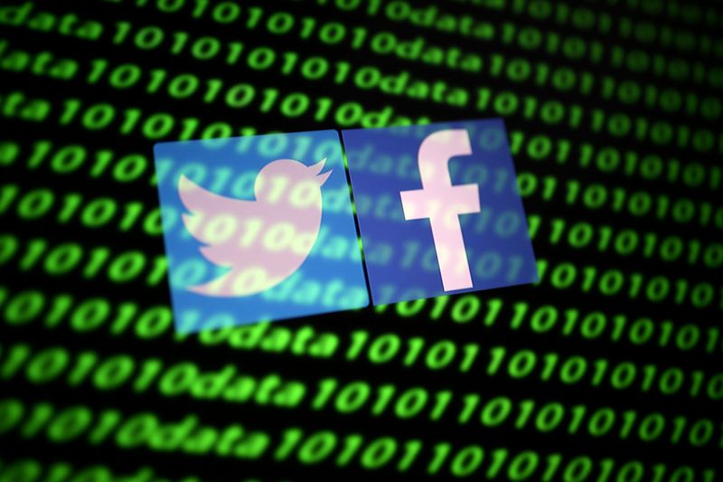 © Reuters. FILE PHOTO: The Twitter and Facebook logos along with binary cyber codes are seen in this illustration