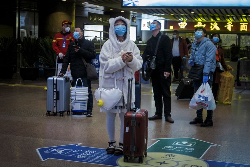 &copy; Reuters. Viajeros usan mascarilla en una estación de trenes luego del brote de coronavirus en Pekín
