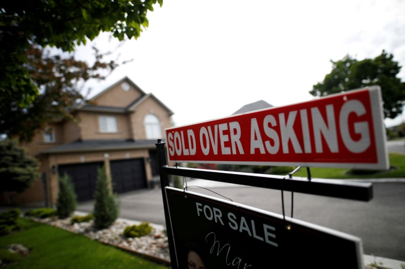&copy; Reuters. FILE PHOTO: A real estate sign that reads &quot;For Sale&quot; and &quot;Sold Above Asking&quot; stands in front of housing in Toronto