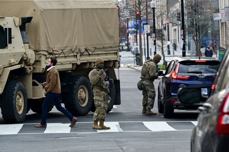 © Reuters. Members of the National Guard check the identification of drivers at a security checkpoint near the White House in Washington