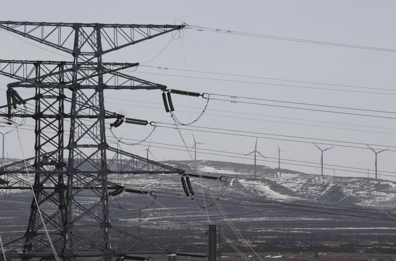 © Reuters. Linhas de transmissão de energia da State Grid e turbinas eólicas na província de Hebei, na China