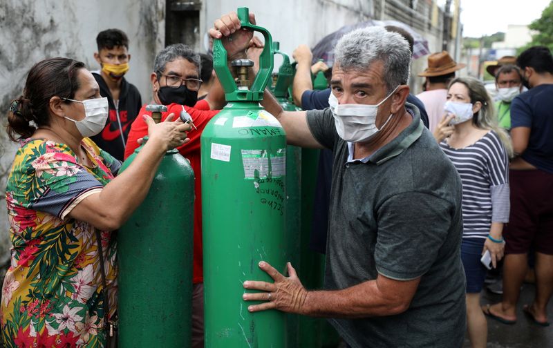 © Reuters. Parentes de pessoas doentes tentam recarregar cilindros de oxigênio em empresa privada em Manaus (AM)