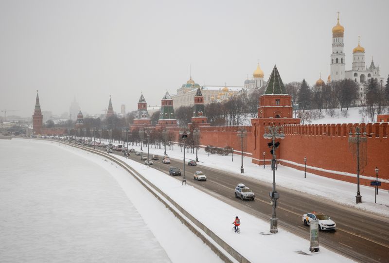 © Reuters. Cars drive along an embankment of the Moskva River near the Kremlin during snowfall in Moscow