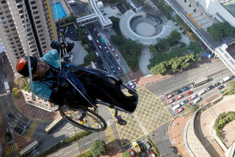 &copy; Reuters. Lai Chi-wai, a paraplegic climber, attempts to climb the 320-metre tall Nina Tower using only his upper body strength, in Hong Kong