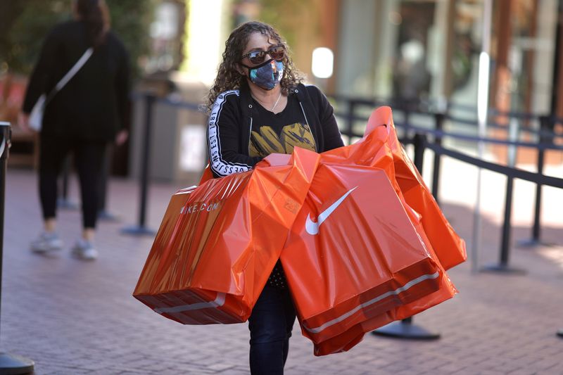 &copy; Reuters. Foto de archivo. Una mujer lleva bolsas de productos de Nike en el centro de compras Citadel Outlet, en Commerce