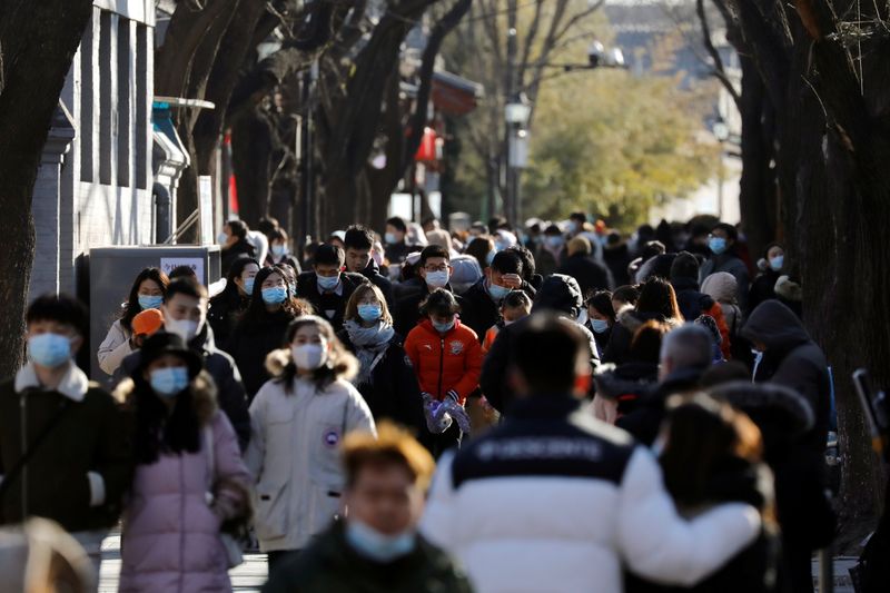 © Reuters. People wearing face masks following the coronavirus disease (COVID-19) outbreak walk along Nanluoguxiang alley