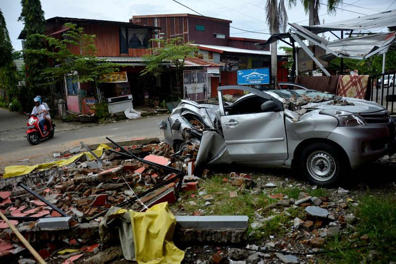 © Reuters. A damaged car is seen among the ruins following an earthquake in Mamuju