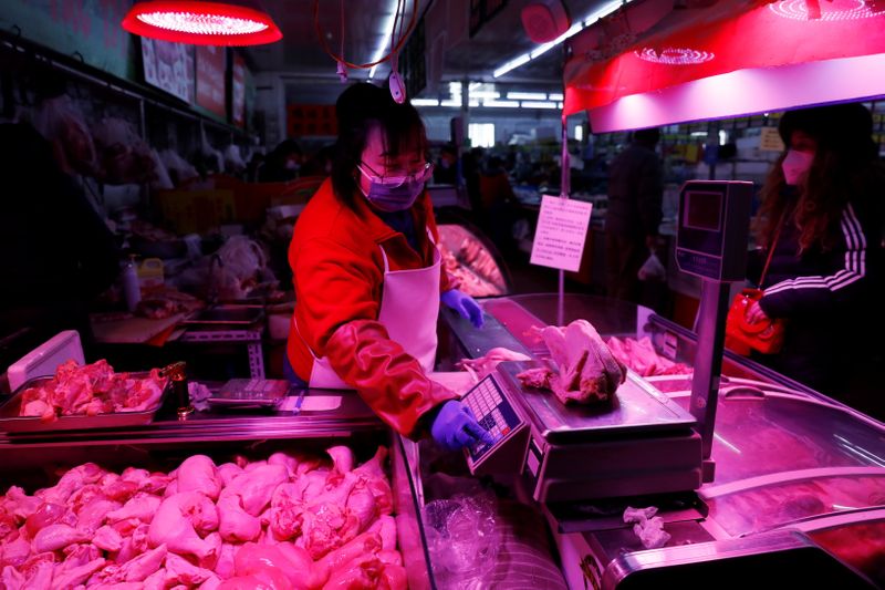 © Reuters. Vendedora pesa frango em mercado de Pequim