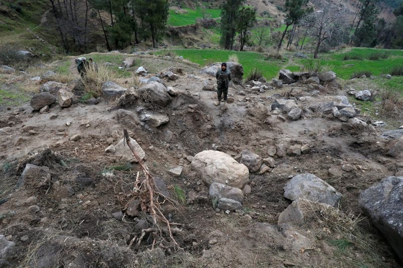 © Reuters. Pakistan's army soldier stands at the edge of a crater, after Indian military aircrafts struck on February 26, according to Pakistani officials, in Jaba village, near Balakot