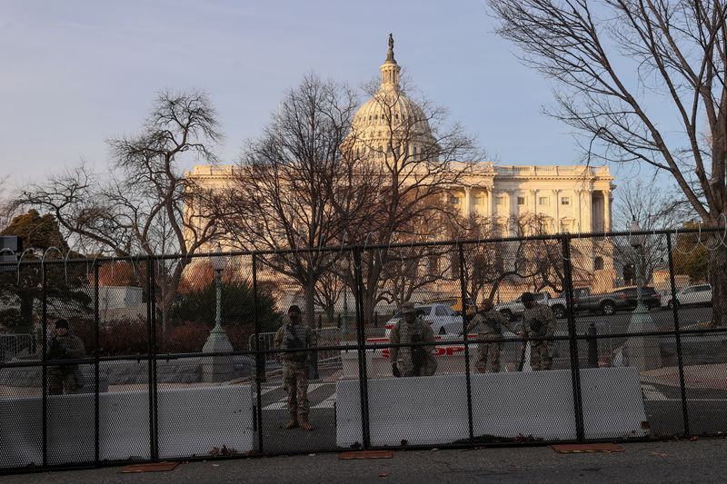 © Reuters. FILE PHOTO: Workers install razor wire atop the unscalable fence surrounding the U.S. Capitol in Washington