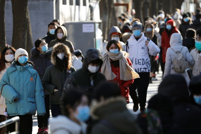 © Reuters. Pessoas andam de máscara em rua de Pequim