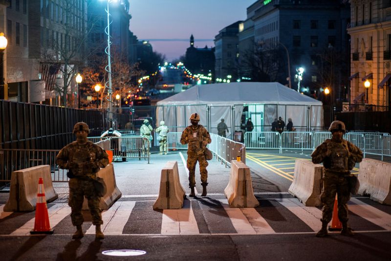 © Reuters. National Guard members get instructions as others stand guard near the White House ahead of U.S. President-elect Joe Biden's inauguration, in Washington