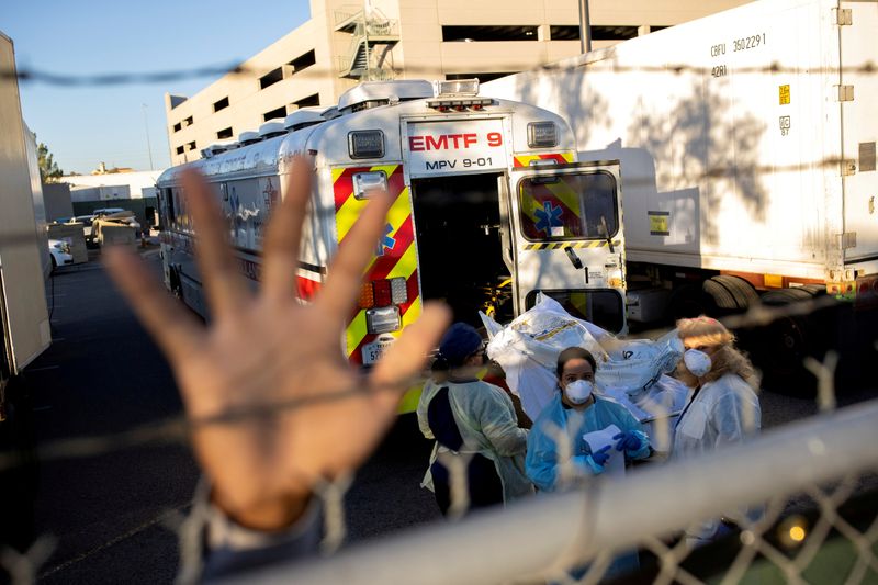 &copy; Reuters. FILE PHOTO: An El Paso County Sheriff&apos;s Officer tries to block photographs from being taken as bodies are moved to refrigerated trailer