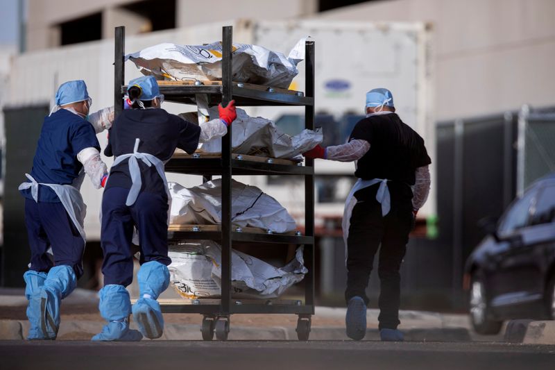 © Reuters. FILE PHOTO: El Paso County Medical Examiner's Office staff move bodies in El Paso