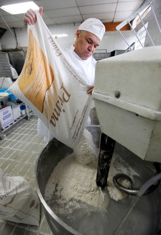 &copy; Reuters. Trabalhador utiliza farinha de trigo na produção de pães em padaria em São Paulo (SP)