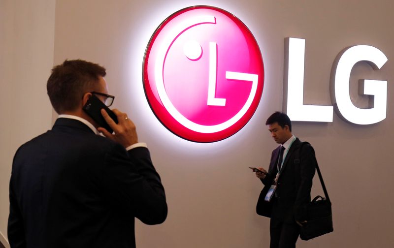 &copy; Reuters. Visitors use their mobile phones next to LG booth during the Mobile World Congress in Barcelona