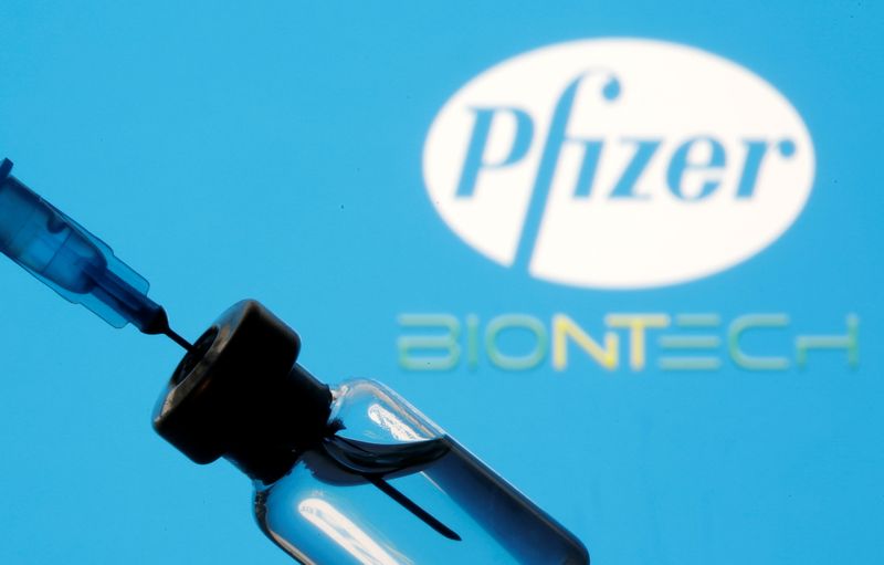 &copy; Reuters. Vial and sryinge are seen in front of displayed Pfizer and Biontech logo