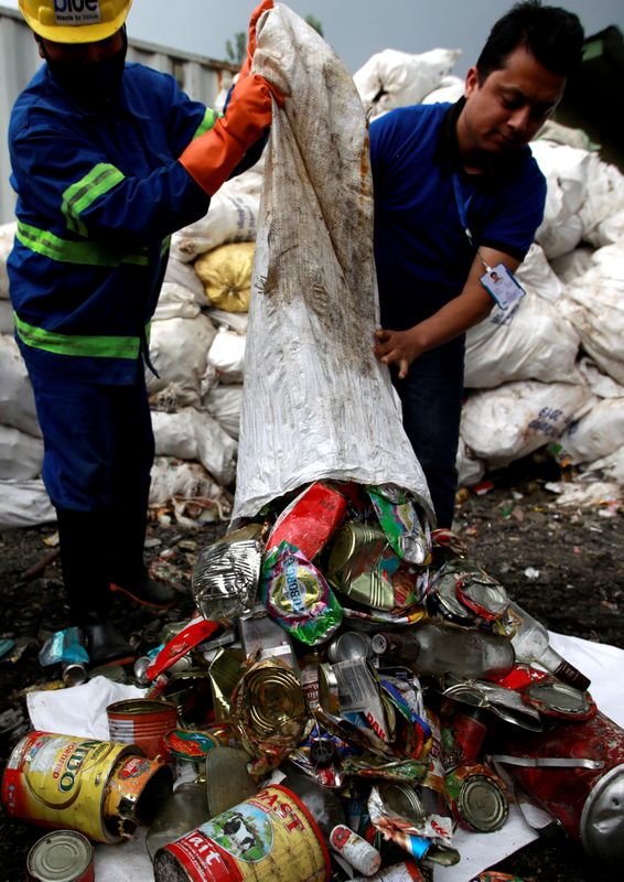 © Reuters. FILE PHOTO: Workers from a recycling company dump garbage collected and brought from Mount Everest out of a bag, in Kathmandu