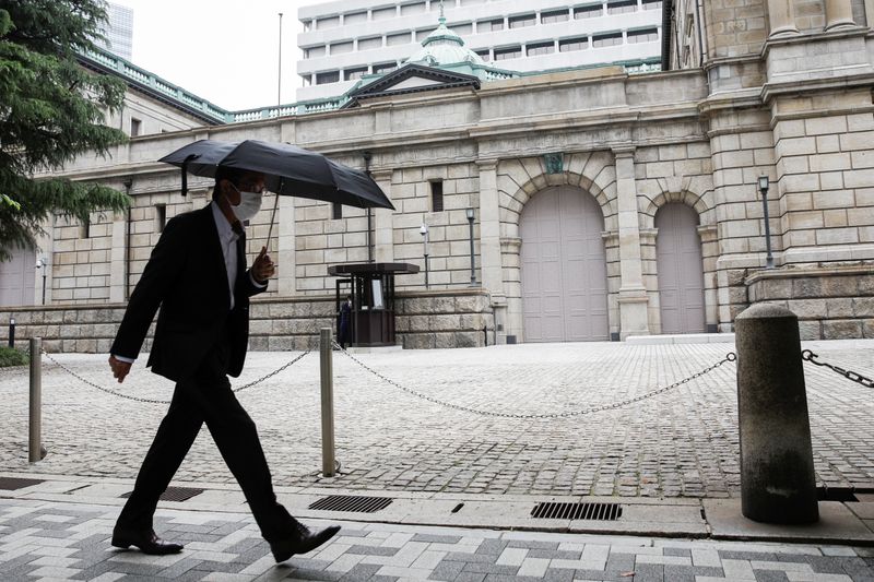 &copy; Reuters. FILE PHOTO: A man wearing a protective mask walks past the headquarters of Bank of Japan amid the coronavirus disease (COVID-19) outbreak in Tokyo