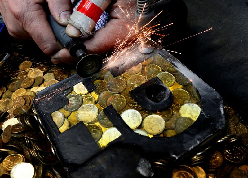 &copy; Reuters. Russian artist Slonov works on his artwork depicting the sign of the Russian rouble in Krasnoyarsk