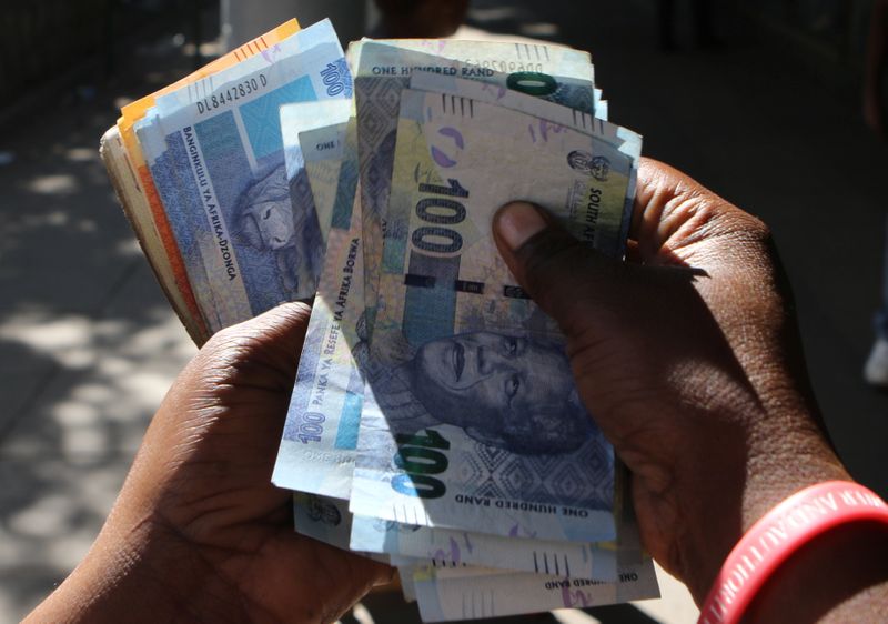 © Reuters. A street money changer counts South African Rands in Harare