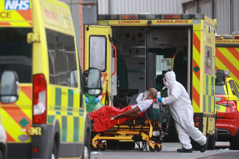 &copy; Reuters. Trabalhadores de saúde transportam paciente em hospital de Londres