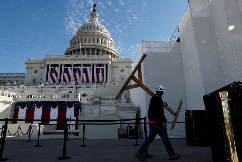 &copy; Reuters. FILE PHOTO:  A worker cleans up the West Front of the U.S. Capitol and dismantles the inaugural platform and seating area the day after President Joe Biden was inaugurated as the 46th president of the United States on Capitol Hill in Washington