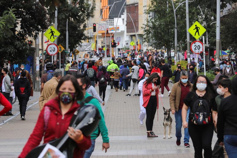 &copy; Reuters. IMAGEN DE ARCHIVO. Personas utilizando mascarillas caminan por una calle antes del inicio de un aislamiento total decretado por la alcaldía, en medio del brote de coronavirus, en Bogotá, Colombia