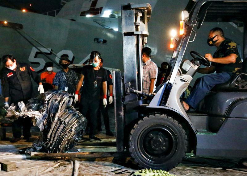 © Reuters. Indonesia Navy personnel uses a forklift to move the turbine of Sriwijaya Air flight SJ 182 on the last day of its search and rescue operation at the Tanjung Priok port in Jakarta