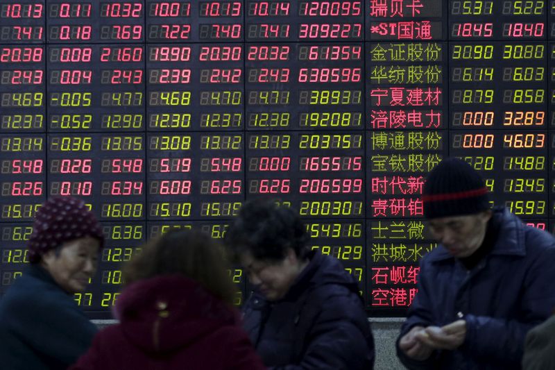 © Reuters. FILE PHOTO: Investors stand in front of an electronic board showing stock information on the first trading day after the week-long Lunar New Year holiday at a brokerage house in Shanghai