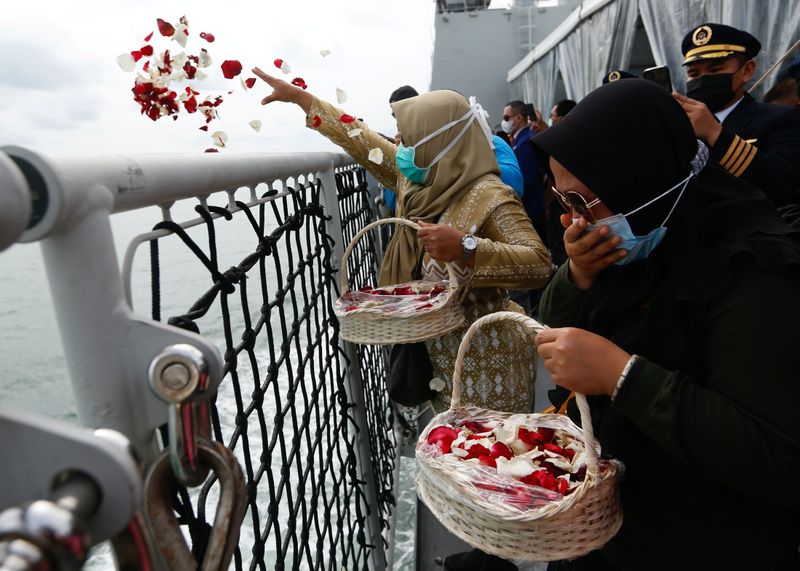 &copy; Reuters. Family members of the passengers of Sriwijaya Air flight SJ 182, which crashed into the sea, react while throwing flowers and petals from the deck of Indonesia&apos;s Naval ship KRI Semarang as they visit the site of the crash to pay their tribute