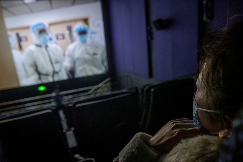 &copy; Reuters. A woman watches the Chinese documentary &quot;Days and Nights in Wuhan&quot; following the outbreak of the coronavirus disease (COVID-19) at a cinema in Beijing