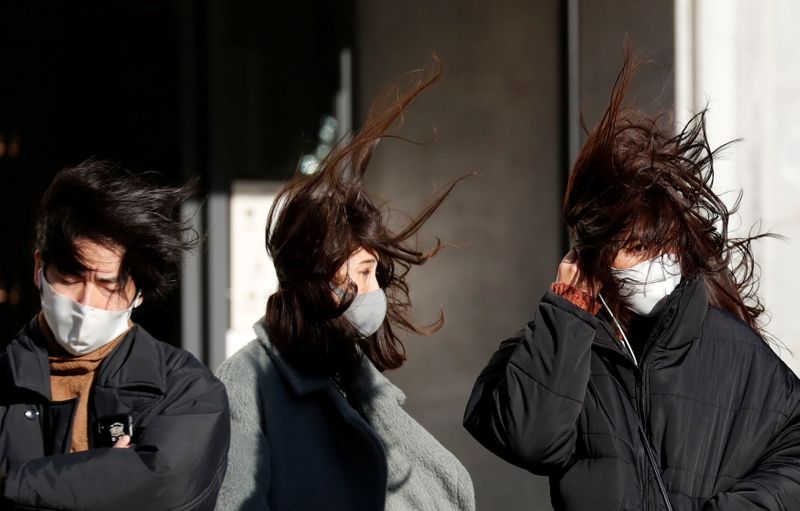 &copy; Reuters. FOTO DE ARCHIVO-Peatones con máscaras protectoras contra COVID-19, se enfrentan a fuertes vientos en Tokio, Japón.
