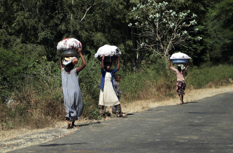 © Reuters. FILE PHOTO: Girls carry laundry in Soroka town in Amhara region near a border with Tigray